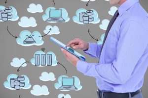 Homem de negócios, segurando uma tablet e icones a sua volta ilustrando o Gerenciamento de TI em nuvem